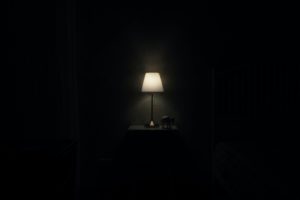 Una lámpara encendida, rodeada de oscuridad.