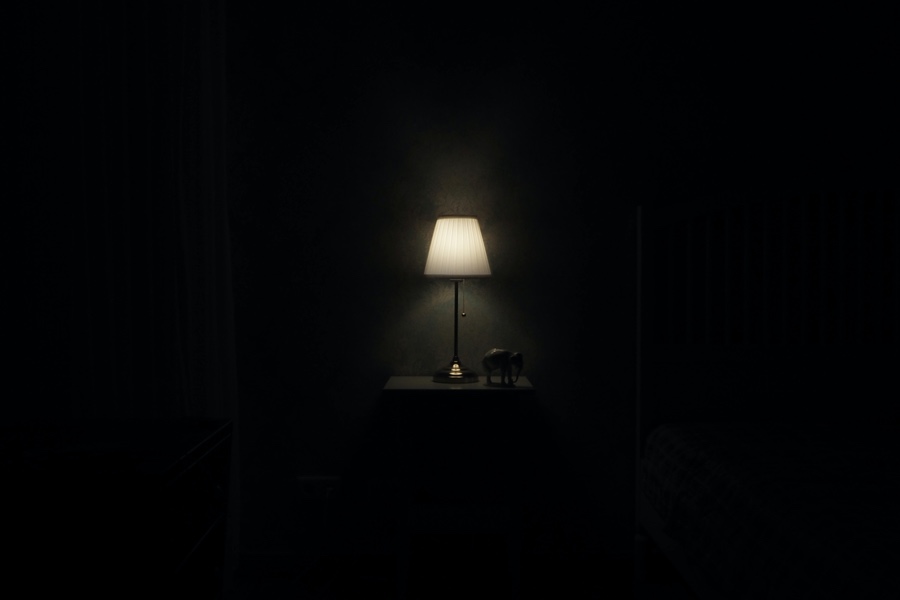 Una lámpara encendida, rodeada de oscuridad.
